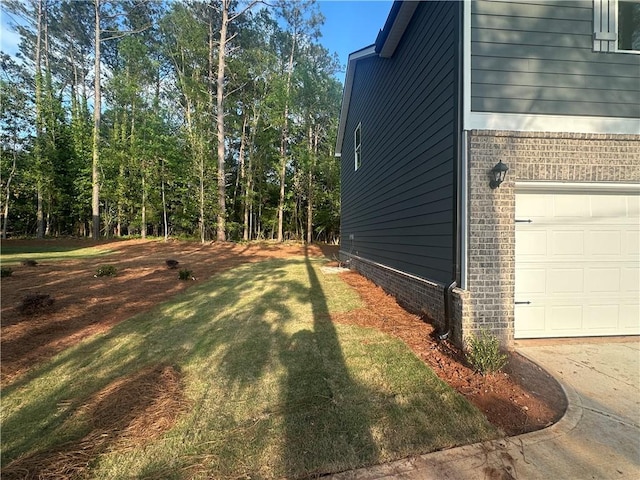 142 Tye St, Stockbridge, GA 30281 - view of side of property featuring a yard, brick siding, and a garage