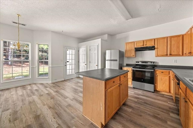 2736 Parkway Trl, Lithonia, GA 30058 - kitchen featuring appliances with stainless steel finishes, under cabinet range hood, dark countertops, a textured ceiling, and light wood-type flooring