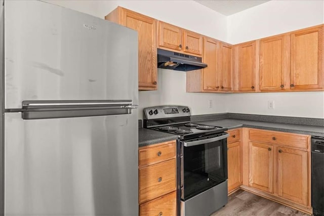 2736 Parkway Trl, Lithonia, GA 30058 - kitchen featuring appliances with stainless steel finishes, under cabinet range hood, dark countertops, and wood finished floors