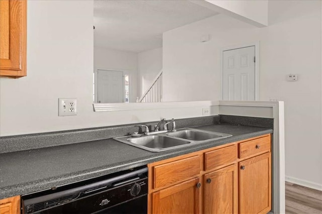 2736 Parkway Trl, Lithonia, GA 30058 - kitchen with dishwasher, a sink, dark countertops, wood finished floors, and brown cabinets