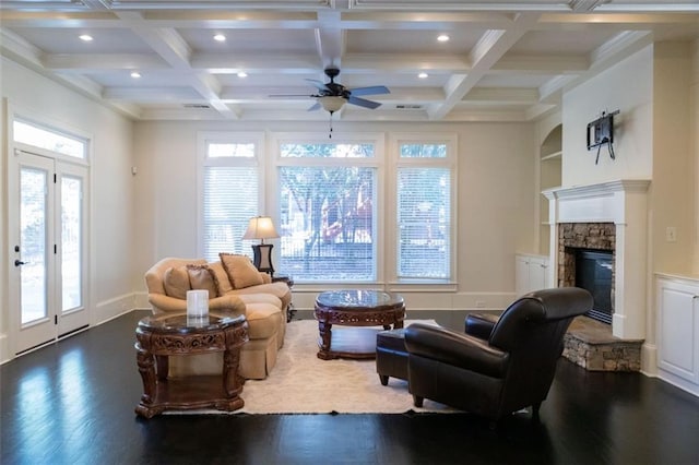 living room with dark hardwood / wood-style floors, plenty of natural light, a fireplace, and beam ceiling