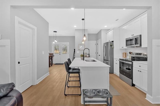 40 Crayton St, Rockmart, GA 30153 - kitchen featuring stainless steel appliances, light wood finished floors, a breakfast bar area, white cabinets, and recessed lighting