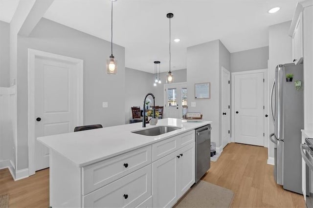 40 Crayton St, Rockmart, GA 30153 - kitchen with stainless steel appliances, light wood finished floors, white cabinets, light countertops, and decorative light fixtures