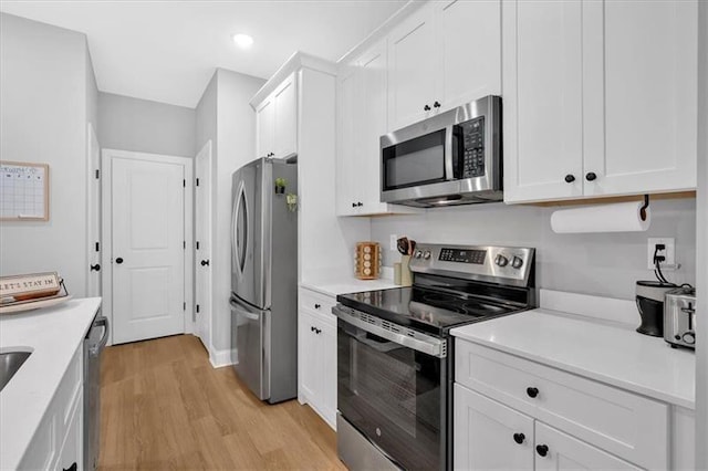 40 Crayton St, Rockmart, GA 30153 - kitchen with appliances with stainless steel finishes, light wood-type flooring, light countertops, white cabinets, and recessed lighting