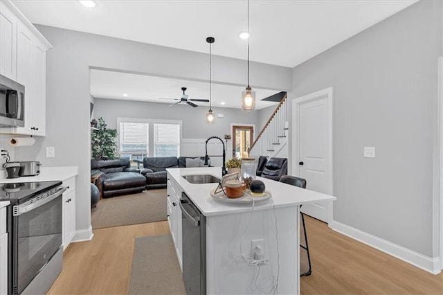 40 Crayton St, Rockmart, GA 30153 - kitchen featuring appliances with stainless steel finishes, light wood-style floors, open floor plan, white cabinets, and light countertops
