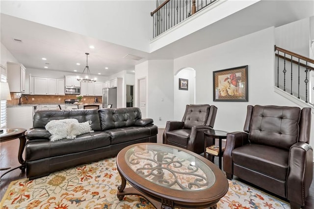 5285 Winflow Way, Suwanee, GA 30024 - living area with a chandelier, arched walkways, stairway, recessed lighting, and a high ceiling