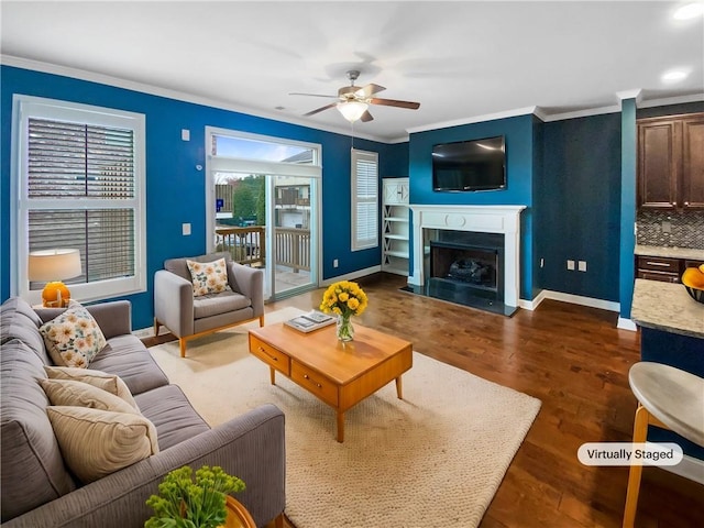 living room featuring a fireplace with flush hearth, baseboards, dark wood finished floors, and crown molding