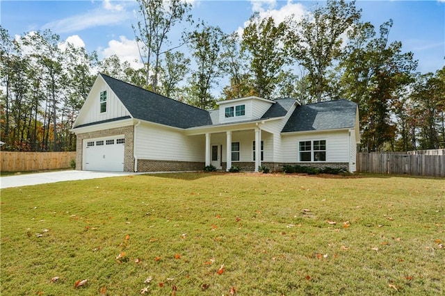 view of front of house featuring a front lawn, covered porch, and a garage