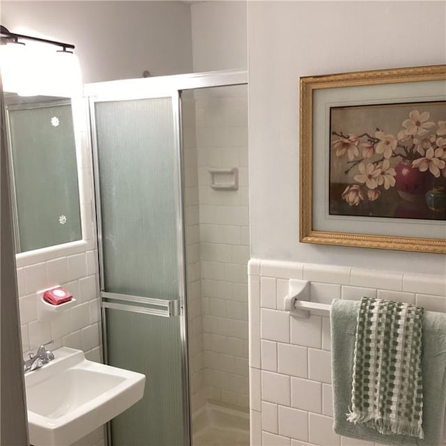 307 Adair St Unit 7-E, Decatur, GA 30030 - bathroom featuring tile walls, a sink, a stall shower, and wainscoting