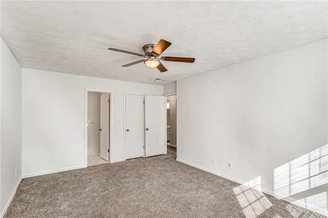 unfurnished bedroom with baseboards, carpet, a textured ceiling, a ceiling fan, and connected bathroom