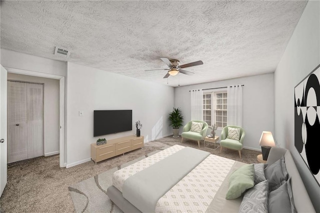 bedroom with carpet floors, ceiling fan, baseboards, and a textured ceiling