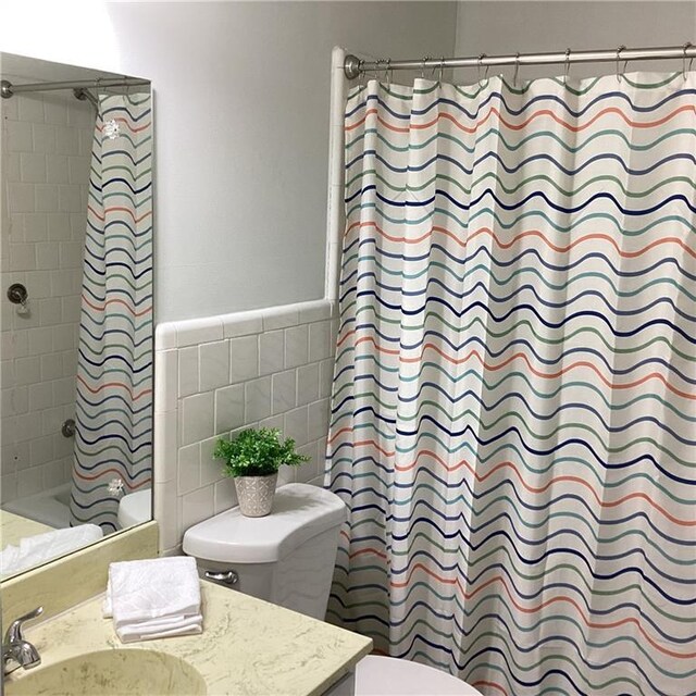 307 Adair St Unit 7-E, Decatur, GA 30030 - bathroom with toilet, vanity, tile walls, shower / tub combo with curtain, and wainscoting
