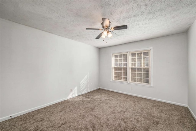 carpeted empty room with a ceiling fan, baseboards, and a textured ceiling