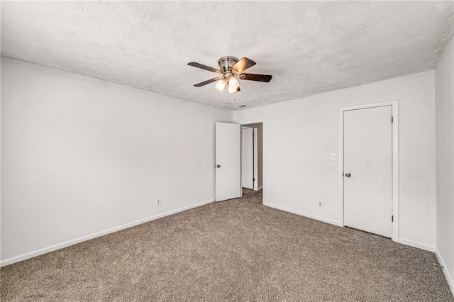 unfurnished bedroom featuring carpet flooring, baseboards, a textured ceiling, and ceiling fan