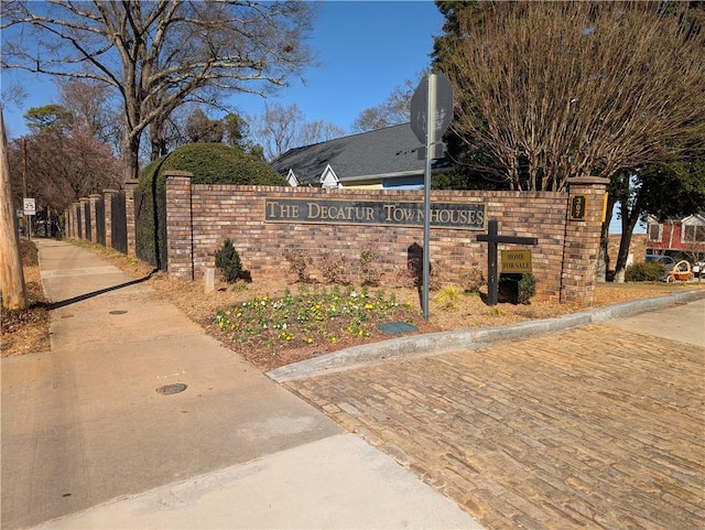 community / neighborhood sign featuring fence