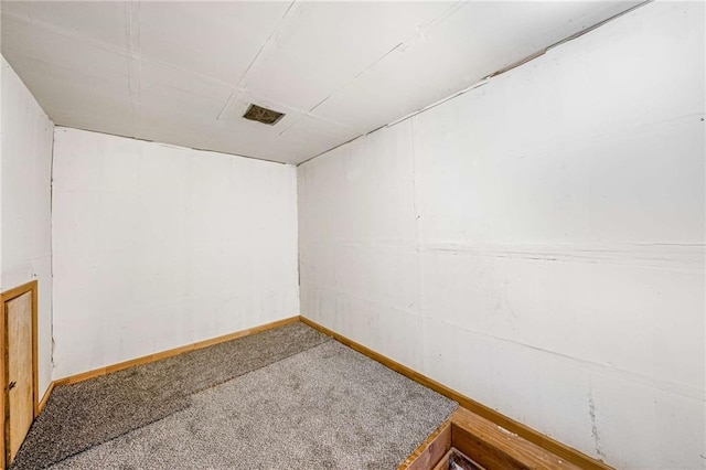 spare room featuring carpet flooring and baseboards
