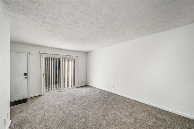 unfurnished room featuring baseboards, a textured ceiling, and carpet flooring