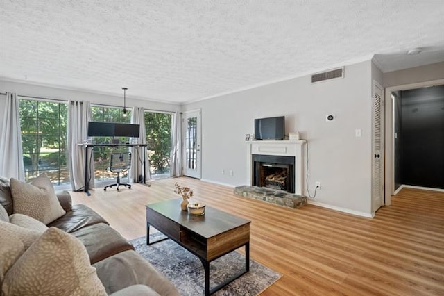 living room with a fireplace, light hardwood / wood-style floors, and a textured ceiling