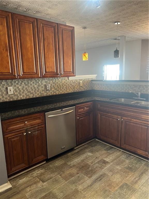 kitchen with pendant lighting, tasteful backsplash, stainless steel dishwasher, a sink, and a textured ceiling