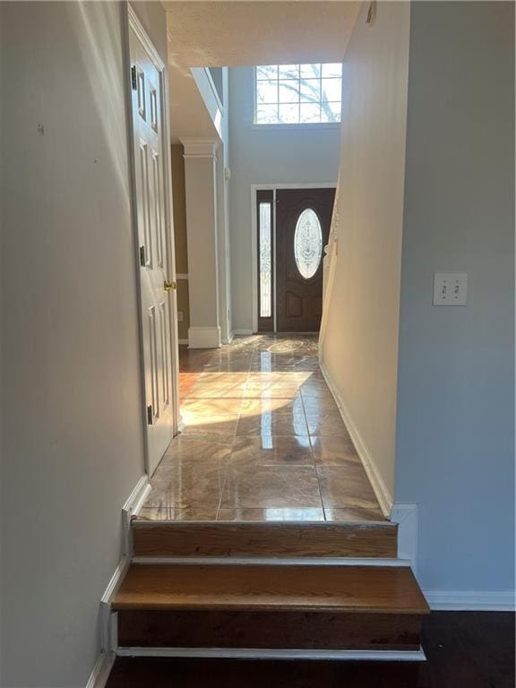 interior space featuring a towering ceiling and baseboards