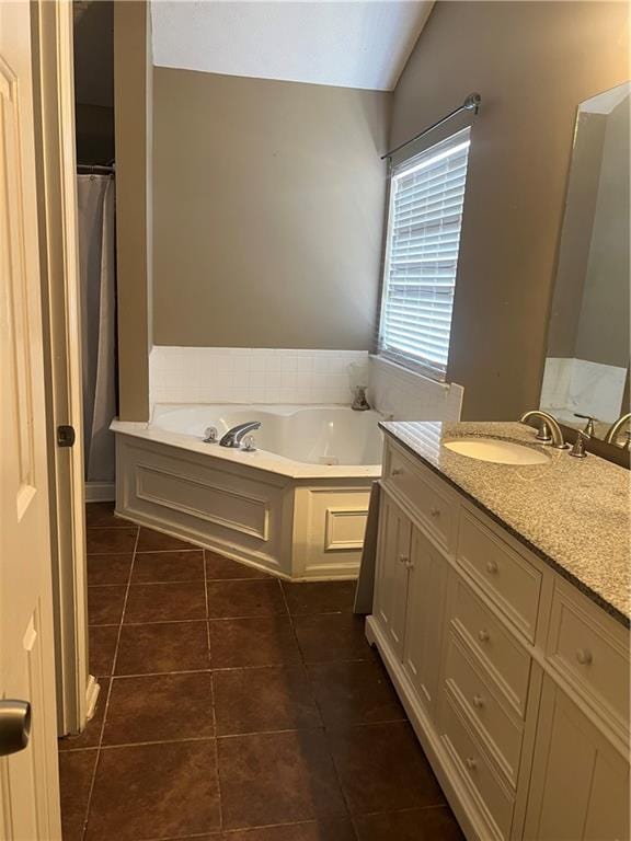 full bath with lofted ceiling, a garden tub, vanity, and tile patterned floors