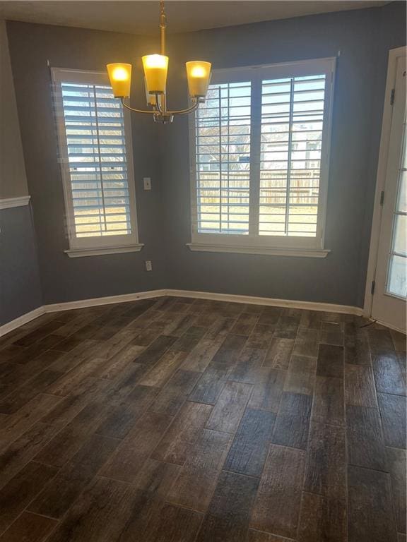 unfurnished dining area featuring dark wood finished floors and baseboards