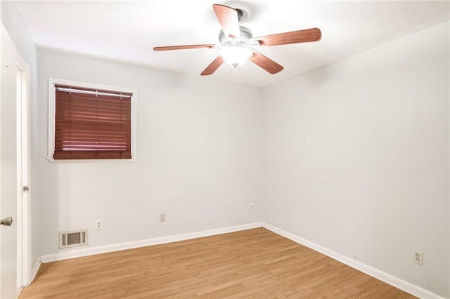 spare room with light wood-style floors, baseboards, visible vents, and a ceiling fan