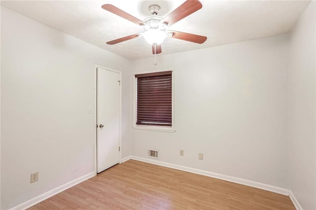 unfurnished room with light wood-style floors, baseboards, visible vents, and ceiling fan