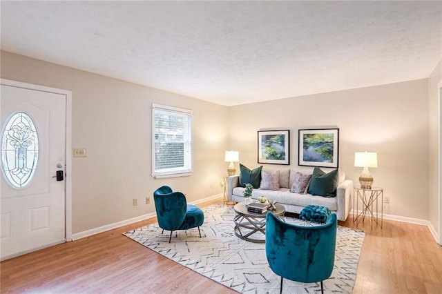 living area featuring light wood-style flooring and baseboards