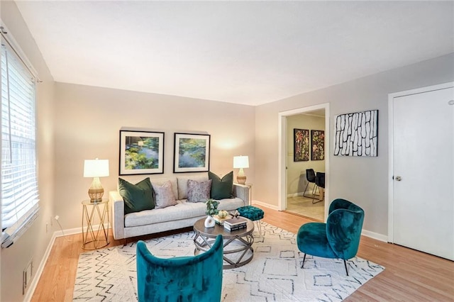 living room featuring a healthy amount of sunlight, light wood-type flooring, and baseboards