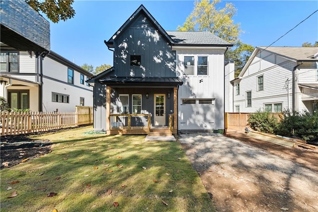 back of property with a garage, a yard, and a porch