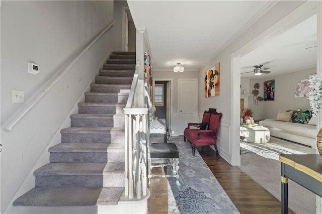 stairway featuring ceiling fan, crown molding, and hardwood / wood-style flooring