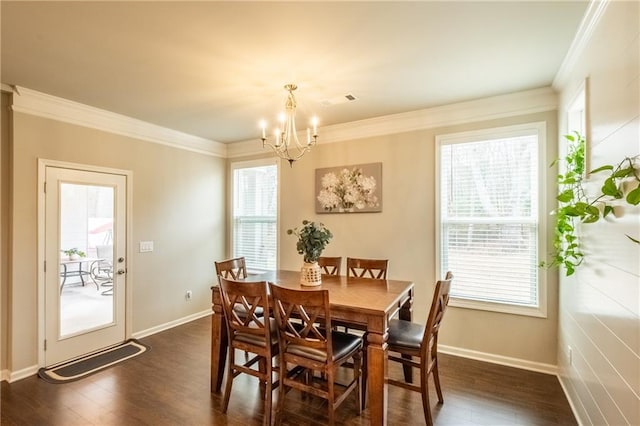 dining room with crown molding, dark hardwood / wood-style flooring, and an inviting chandelier