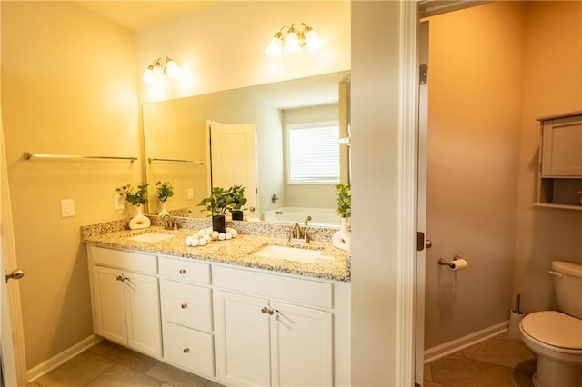 bathroom with tile patterned flooring, vanity, a tub to relax in, and toilet