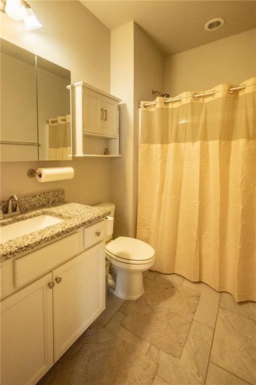 bathroom featuring vanity, curtained shower, and toilet