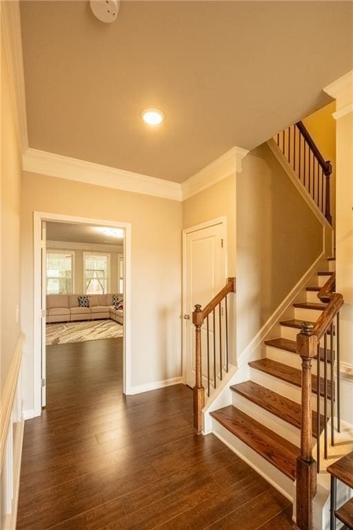 staircase featuring wood-type flooring and crown molding