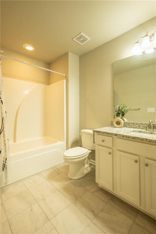 full bathroom featuring shower / tub combo, vanity, and toilet