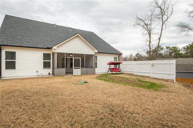 back of property with a lawn and a sunroom