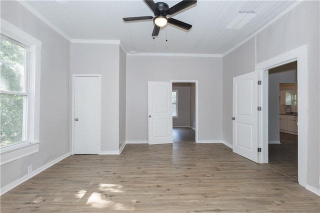 unfurnished room featuring sink, ornamental molding, ceiling fan, and light wood-type flooring