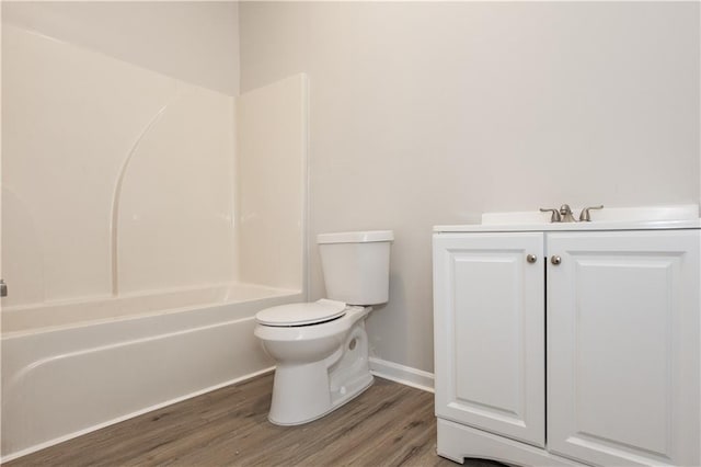 full bathroom with hardwood / wood-style flooring, vanity, shower / tub combination, and toilet