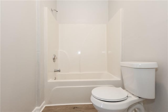 bathroom with hardwood / wood-style flooring, toilet, and shower / bath combination