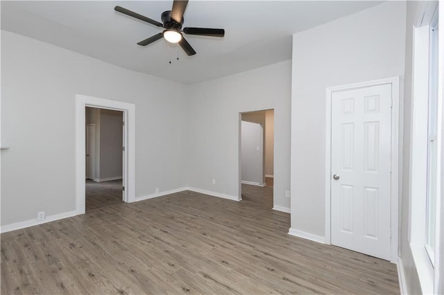 empty room with ceiling fan and light hardwood / wood-style flooring