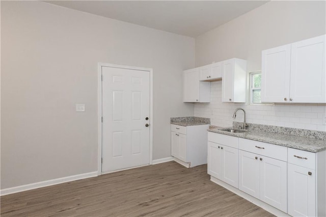 kitchen featuring backsplash, sink, and white cabinets