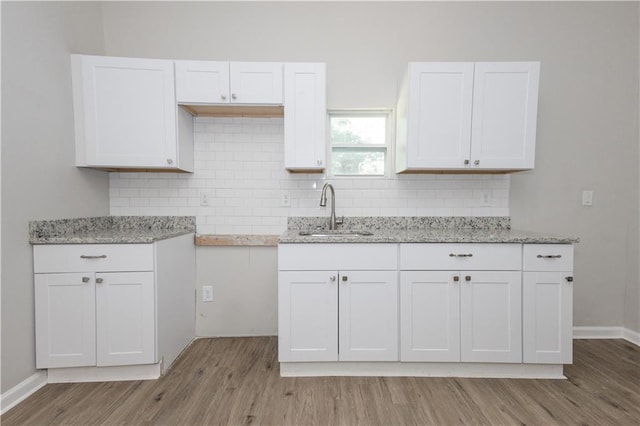 kitchen with white cabinetry, sink, and decorative backsplash