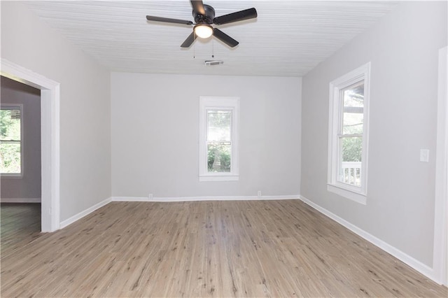 spare room featuring ceiling fan, light hardwood / wood-style flooring, and a healthy amount of sunlight