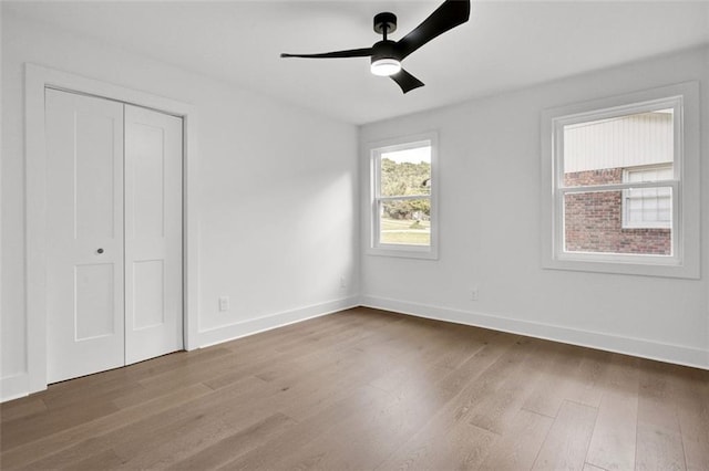 unfurnished bedroom featuring hardwood / wood-style flooring, a closet, and ceiling fan