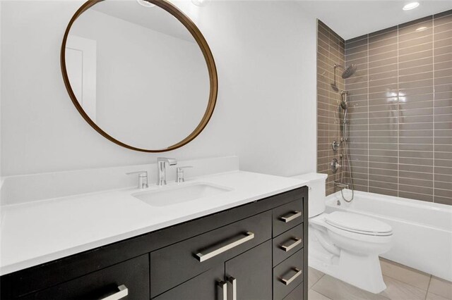 full bathroom with tiled shower / bath combo, vanity, tile patterned flooring, and toilet