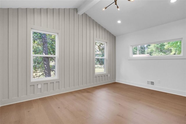 empty room featuring a notable chandelier, wood-type flooring, and lofted ceiling with beams