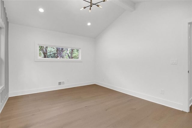 spare room with lofted ceiling with beams, wood-type flooring, and a notable chandelier