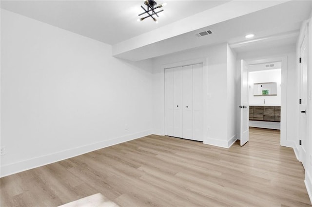 unfurnished bedroom with a closet and light wood-type flooring